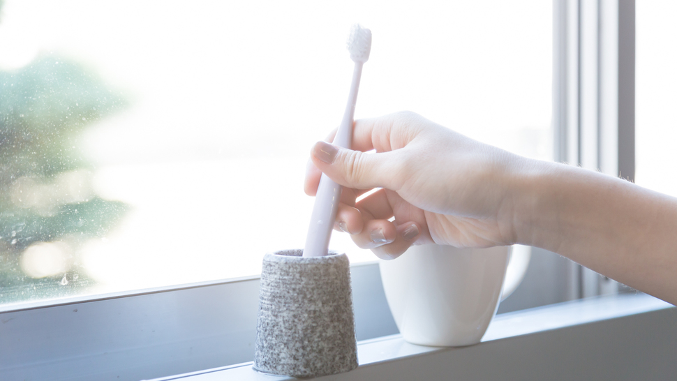 woman-pick-toothbrush-from-toothbrush-stand